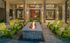 Inviting outdoor lounge area with a stylish fire pit surrounded by vibrant green Adirondack chairs, perfect for cozy evenings.
