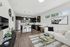 open-plan living space with sleek kitchen, stylish bar seating, and cozy lounge area featuring modern decor.