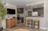 Contemporary open-concept kitchen and living area with sleek cabinetry, cozy breakfast bar, and stylish decor.