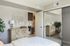 Bright and airy bedroom featuring modern decor, a stylish dresser, and a large mirrored closet.