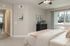 Bright and inviting bedroom with neutral tones, large window offering natural light, and elegant decor accentuating a cozy atmosphere.