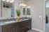 Modern bathroom featuring dual sinks with sleek fixtures, elegant mirrors, and stylish decor.