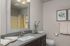Elegant bathroom with modern fixtures, featuring a sleek countertop, framed mirror, and tasteful decor.