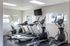 Modern fitness center with state-of-the-art treadmills and ellipticals, bright windows and overhead TV, perfect for an energizing workout.