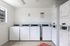 Bright and clean laundry room with multiple washing machines and dryers, providing convenient and efficient laundry services for residents.
