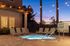 Charming outdoor spa area with lounge chairs and string lights at sunset, perfect for relaxation.