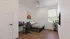 Bright, contemporary bedroom with cozy single bed, sleek workspace, vibrant decor, and large window highlighting natural light.