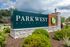 Welcome to Parkwest Apartments, showcasing a stylish entrance sign surrounded by lush greenery and elegant stonework.
