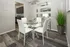 Sleek dining area with a modern glass table, white chairs, and contemporary decor, perfect for stylish gatherings.