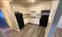 Modern kitchen with sleek white cabinets, stylish granite countertops, and a spacious layout featuring contemporary appliances.
