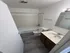 Modern bathroom featuring sleek marble countertop, elegant white bathtub, and stylish wood-look flooring.