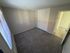 Inviting bedroom with plush carpet, ample closet space, and natural light from a large window.