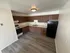 Modern kitchen with sleek wooden cabinets, spacious countertops, and stylish flooring, perfect for culinary enthusiasts.