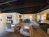 Elegant open-concept living and dining area featuring modern decor, plush seating, and stylish lighting with abundant natural light.