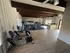Bright, spacious gym with modern exercise equipment and large windows offering natural light.