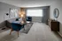 Modern living room with chic gray sofa, vibrant blue chairs, and artistic decor, exuding comfort and style.