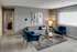 Inviting living room with a modern grey sofa, vibrant blue armchairs, and chic decor, perfect for relaxation and entertaining.