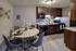 Modern kitchen with dark wood cabinets, sleek appliances, and a chic marble dining table for a stylish, functional space.