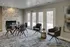 Chic modern living area with elegant dining setup, stylish gray chairs, and expansive windows offering scenic views.