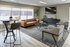 Elegant, modern living room with chic leather sofa, stylish accent chairs, and large windows filling the space with natural light.