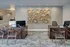 Elegant office lobby with modern wooden desks and artistic wall decor, featuring stylish seating for a welcoming atmosphere.