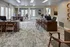 Modern and inviting office space showcasing elegant wooden desks, chic chairs, and abundant natural light through large windows, creating a welcoming atmosphere for productivity.