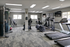 Modern fitness center with state-of-the-art equipment, including treadmills, elliptical machines, and weight stations in a bright, spacious setting.