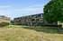 Charming brick apartment building with cozy balconies and lush greenery, offering tranquil suburban living.