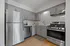 Modern kitchen with sleek stainless steel appliances, elegant gray cabinetry, and bright subway tile backsplash.