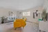 Bright and inviting living room featuring modern gray and yellow seating, complemented by stylish artwork and elegant decor.