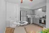 Bright and inviting kitchen with sleek gray cabinets, modern stainless steel appliances, and a cozy dining area perfect for intimate meals.