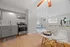 Contemporary open-plan kitchen and living area with elegant gray cabinets, modern appliances, and cozy dining space, perfect for stylish living.