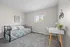 Bright and cozy bedroom featuring a modern daybed, cheerful wall art, and a sleek workspace with ample natural light.