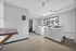 Bright and welcoming laundry room featuring modern washers and dryers with ample natural lighting and a convenient folding area.