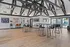 Modern community clubhouse with stylish high ceilings, featuring sleek bar stools, spacious seating areas, and vibrant views of the outdoor pool. includes full kitchen