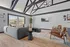 Contemporary community club house living room with stylish vaulted ceiling, cozy gray sofa, elegant armchairs, and unique modern decor, perfect for relaxation and entertainment.
