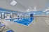 Spacious indoor pool area with sleek blue lounges and abundant natural light, offering a perfect leisure retreat.