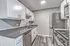 Modern kitchen with sleek grey countertops, stainless steel appliances, and elegant white cabinetry.