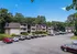 Charming apartment complex with modern architecture, lush greenery, and spacious parking surrounded by serene natural views.