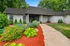 Charming apartment entrance surrounded by lush greenery and vibrant flowers, offering a serene and inviting atmosphere.