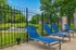 Inviting outdoor area with blue lounge chairs overlooking a serene pond and lush greenery.