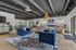 Modern and luxurious open-concept living room with elegant blue velvet chairs, stylish lighting, and contemporary artwork.