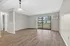 Bright and spacious living room with elegant hardwood floors and large sliding glass doors opening to a serene outdoor view.