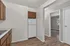 Contemporary kitchen with sleek white walls, inviting wooden cabinetry, and elegant hardwood flooring, leading into a bright and cozy room.