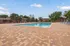 Inviting outdoor swimming pool area with stylish lounge chairs and beautiful brick paving, perfect for relaxation and leisure.