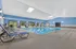 Inviting indoor pool area with bright blue walls, natural light, and stylish lounge chairs.