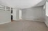 Bright and welcoming living room with plush carpeting, modern open kitchen view, and neutral walls offering a blank canvas.