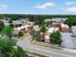 Aerial view of a charming apartment complex surrounded by lush greenery and ample parking, showcasing a peaceful suburban neighborhood.