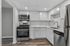 Modern kitchen with sleek stainless steel appliances, elegant white cabinetry, and stylish wood flooring for a bright and functional culinary space.