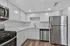 Modern kitchen with sleek countertops, stainless steel appliances, and elegant white cabinetry.